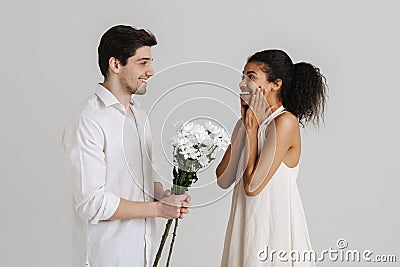 European man giving black woman chrysanthemum bouquet Stock Photo