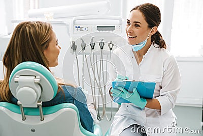 European mid dentist woman smiling while working with patient Stock Photo