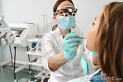 European dentist woman using microscope while working in dental clinic Stock Photo