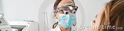 European dentist woman using microscope while working in dental clinic Stock Photo