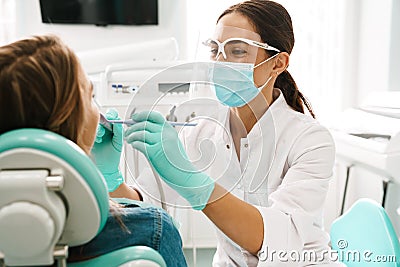 European mid dentist woman in face mask working in dental clinic Stock Photo