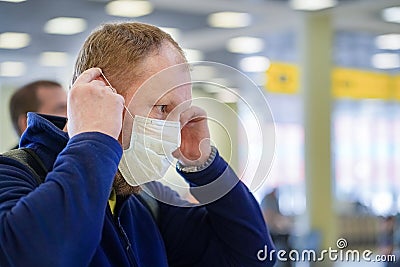 European redbeard man is in protective medical mask in airport. Editorial Stock Photo