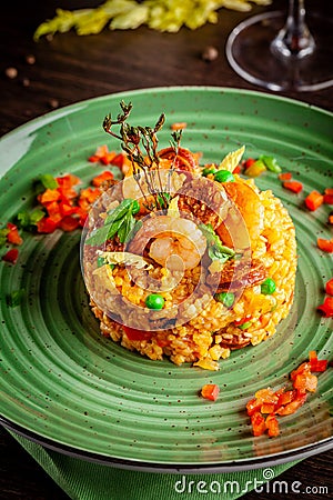 European Spanish cuisine. Paella with shrimps, chicken and coblas chorizo. White wine on the table. Closeup background image Stock Photo