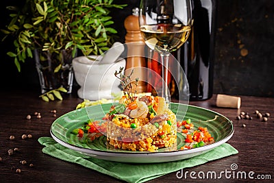 European Spanish cuisine. Paella with shrimps, chicken and coblas chorizo. White wine on the table. Closeup background image Stock Photo