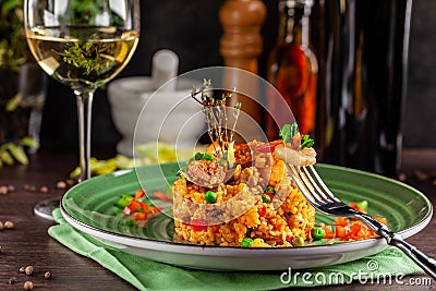 European Spanish cuisine. Paella with shrimps, chicken and coblas chorizo. White wine on the table. Closeup background image Stock Photo