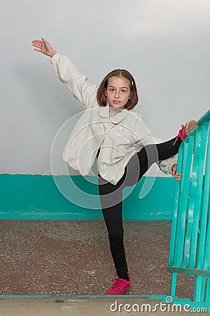 European sporty girl in casual clothes showing vertical twine outdoor. Stretching training Stock Photo