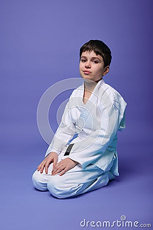 European teenage boy - aikido fighter in a white kimono during the practice of oriental martial arts Stock Photo