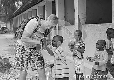 European tourist showing camera to african children Editorial Stock Photo