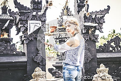 European young lady at balinese traditional temple. Bali island, Indonesia. Stock Photo