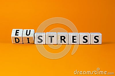 Eustress or distress symbol. Turned wooden cubes and changed the concept word Eustress to Distress. Beautiful orange table orange Stock Photo