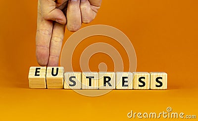 Eustress or stress symbol. Psychologist turns cubes and changes the concept word Eustress to Stress. Beautiful orange table orange Stock Photo