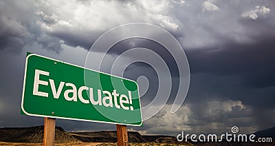 Evacuate Green Road Sign and Stormy Clouds Stock Photo