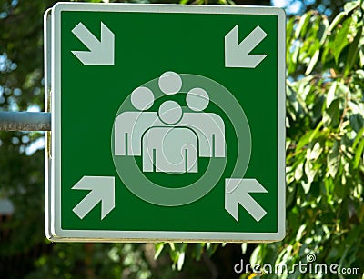 Evacuation assembly point sign in green and white. Gathering point board to lead people to a safe place during an emergency. Stock Photo