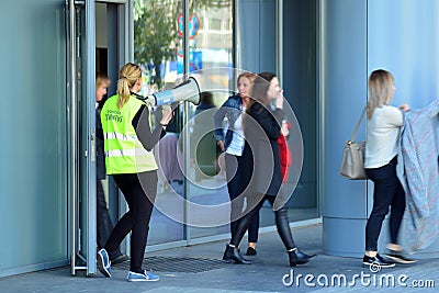 Evacuation of an office building. People exit the building on exit door. Editorial Stock Photo