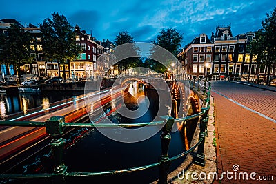 Evening in Amsterdam city, light trails and reflections on water at the Leidsegracht and Keizersgracht canals. Long Stock Photo