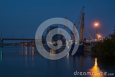 Evening dock view with ships and dockside cargo crane Stock Photo