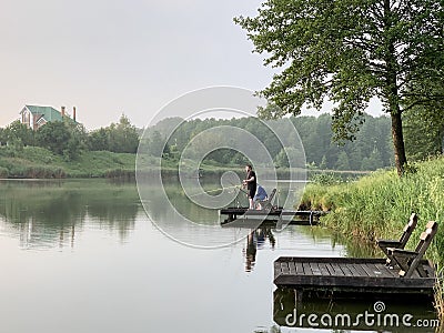 Evening landscape on a lake in the forest. Fishing, Sunset on a forest pond. Fishing platform on the river Editorial Stock Photo