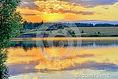 Evening landscape screensaver on the lake with the reflection in the water of the evening sky filled with sun. Stock Photo