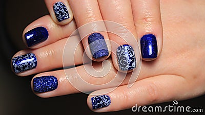 Evening manicure, design cold colors, blue gel polish with silver ribbons and pattern Stock Photo