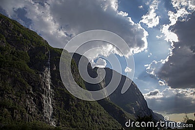 Evening shot of beautiful fjord valley, surrounded by mountains, cloudy blue skies Stock Photo