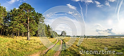 Evening summer landscape with lush pine tree on the banks of river and dirt road, Russia, Ural Stock Photo