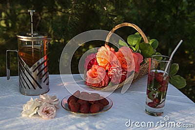 Evening tea and fruit at sunset. Roses glow in the sunset Stock Photo