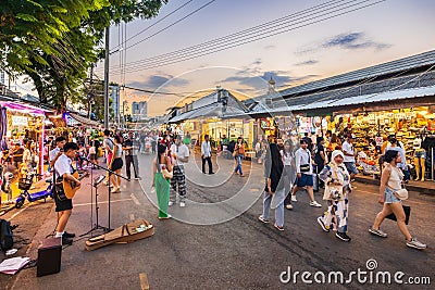 Evening time At Chatuchak Market, witness young performers and street musicians showcasing diverse talents through busking and Editorial Stock Photo