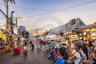 Evening time At Chatuchak Market, witness young performers and street musicians showcasing diverse talents through busking and Editorial Stock Photo