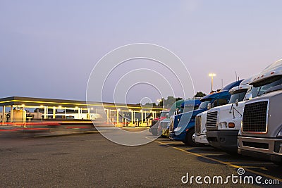 Evening truck stop lights of number of trucks in parking Stock Photo