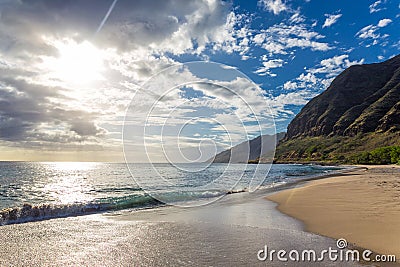 Evening view with sun shining throug clouds at Makua beach, Oahu Stock Photo