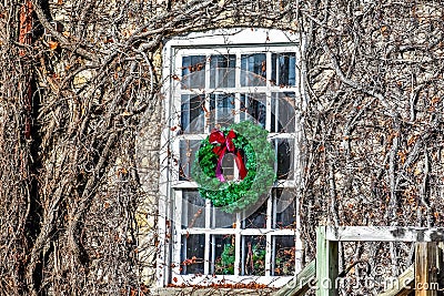 Christmas Wreath with Red Bow Hanging on Window Stock Photo