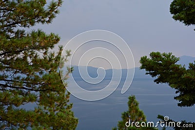 Evergreen Trees in Foreground of Lake and Mountains Stock Photo