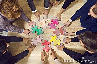 Colored puzzle pieces that business people connect together during team building. Stock Photo