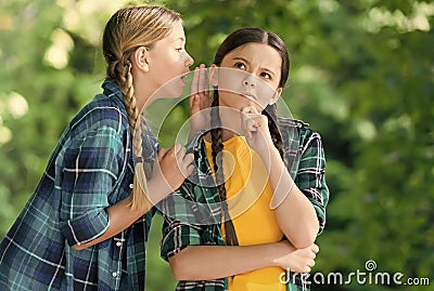 Everybody knows that. Chattering girls summer outdoors. Little child whisper news in friends ear. Top secret. Hearing Stock Photo