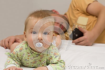 Everyday business dad while working in the home office, holding a smartphone and looking at the screen. Close up Stock Photo