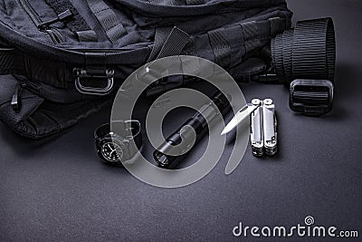 Everyday carry EDC items for men in black color - backpack, tactical belt, flashlight, watch and silver multi tool. Stock Photo