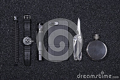 Everyday carry EDC military items for men- multi tool, lighter, phone, tactical watch, survival bracelet,flashlight and flask. Stock Photo