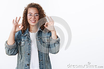 Everything perfect recommend. Attractive curly-haired young freelance girl show approval okay ok gesture smiling pleased Stock Photo