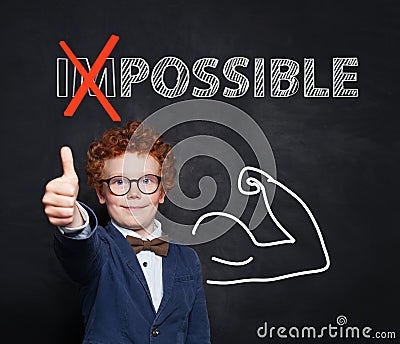 Everything is possible. Smart kid showing thumb up against text possible with crossed out im on chalkboard background Stock Photo