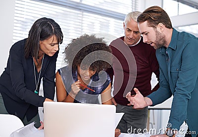 Everythings going according to plan. a group of architects using a laptop to work on their designs. Stock Photo