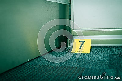 Evidence marker number 7 on carpet floor near suspect object in Stock Photo