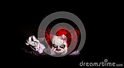 The evil clown killer peeps out of cover. horror. halloween concept. evil look Stock Photo