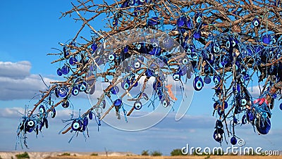 Evil eye charms, traditional turkish blue glass beads hanging on bare tree in ,Cappadocia, Turkey. Stock Photo