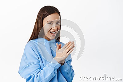 Evil genius face. Smiling young girl plan smth, relish money, rub hands and laughing, scheming interesting prank, has an Stock Photo