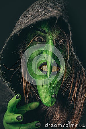 Evil witch casting a curse under her hood Stock Photo