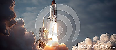 An evocative image of a space shuttle launch, with plumes of smoke and fire visible as it lifts off into the sky Stock Photo