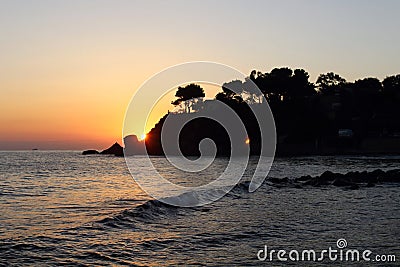 Sunrise over the sea with the sun rising over the horizon Stock Photo