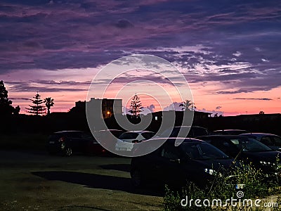 sunset with silhouette of houses and trees in the background Stock Photo