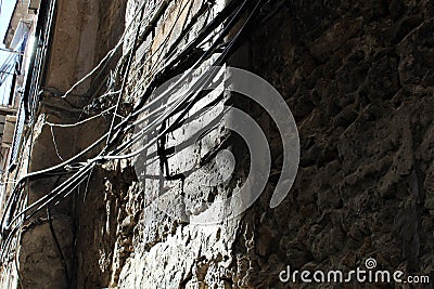 Water pipes and electricity wires positioned on the facade of an ancient building Stock Photo