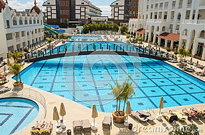 Huge empty pool with blue transparent water on the territory of a resort hotel Editorial Stock Photo
